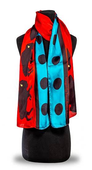 Vibrant red and turquoise Native-inspired scarf with black polka dots and animal motifs, displayed on mannequin.