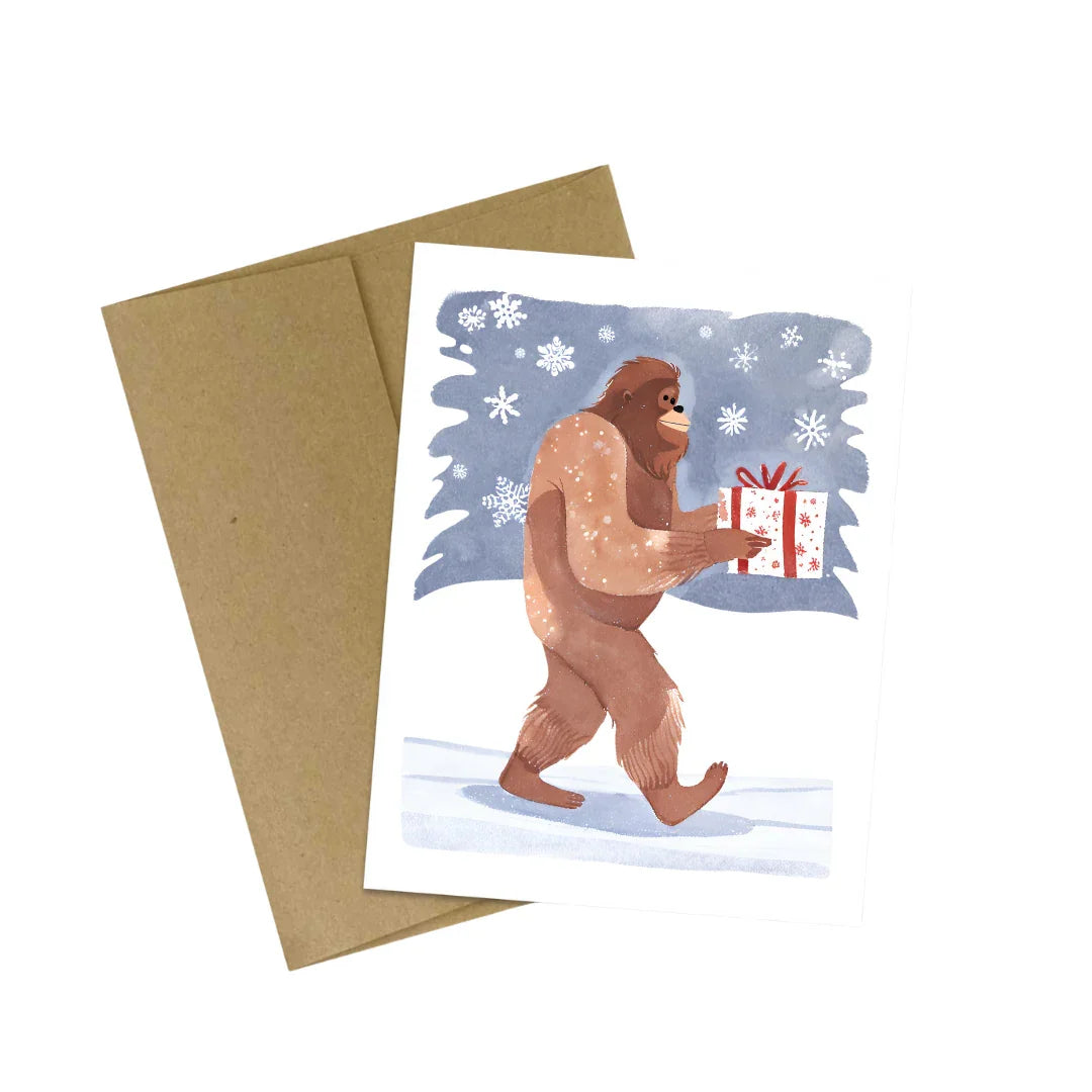 Bigfoot Carrying a Christmas Present in the Snow Card : Brown Kraft Paper
