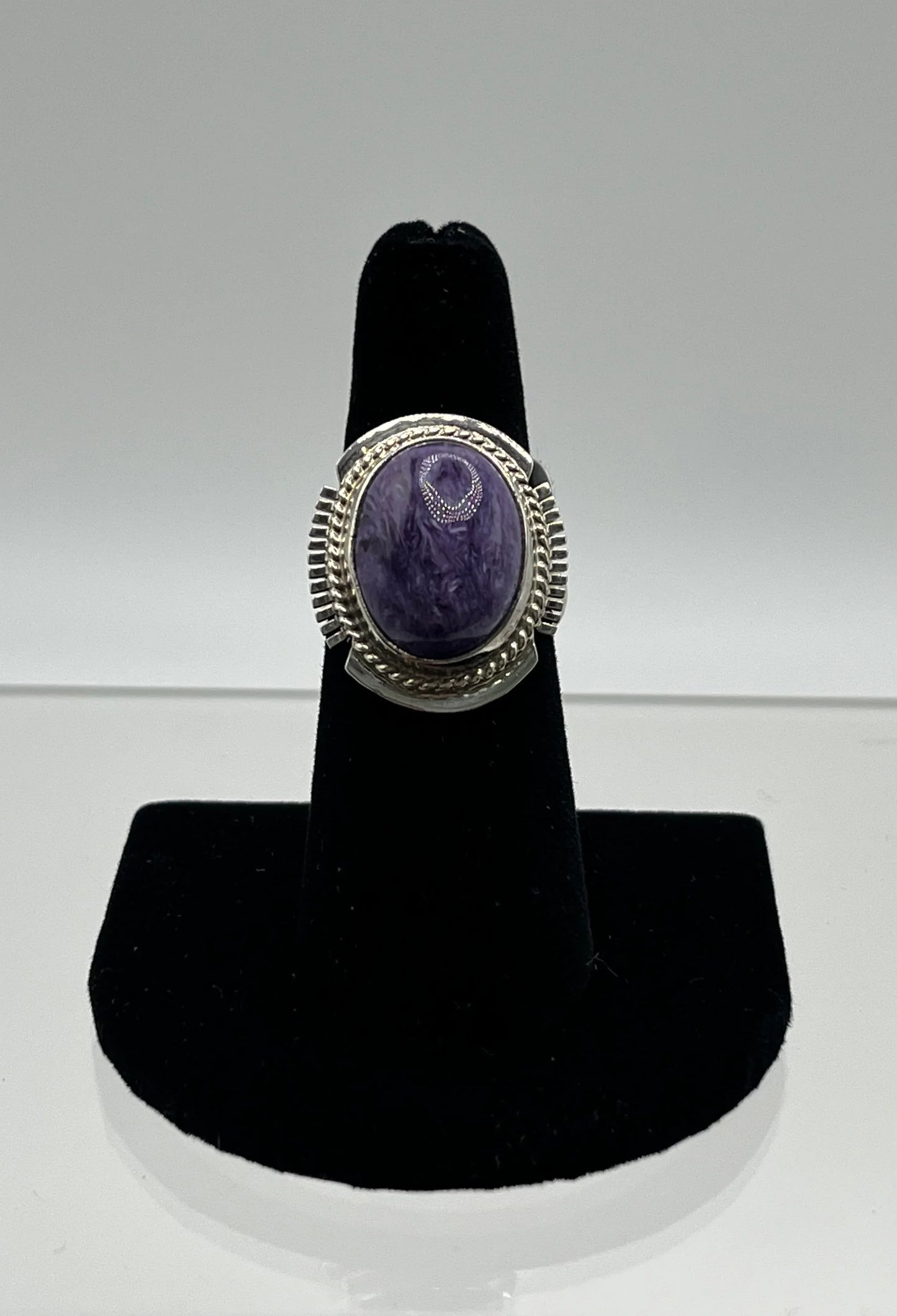 Purple stone ring with silver filigree, displayed on black stand, Native American jewelry style