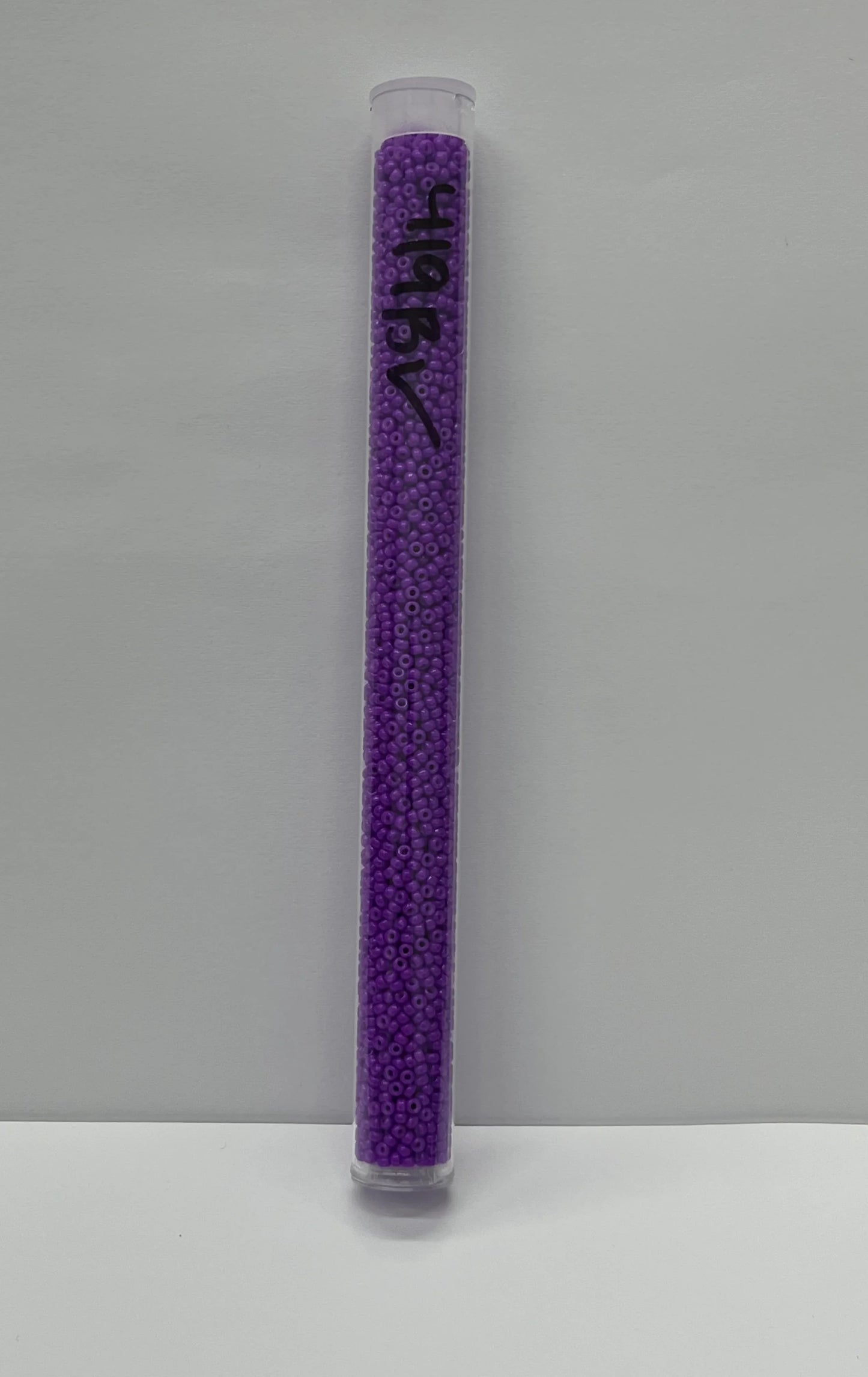 Purple seed beads in clear tube for Native American crafts and traditional clothing projects