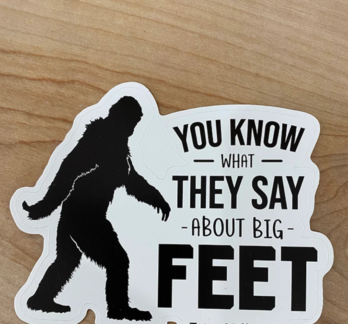 Bigfoot sticker with 'You know what they say about big feet' text, humorous Sasquatch design