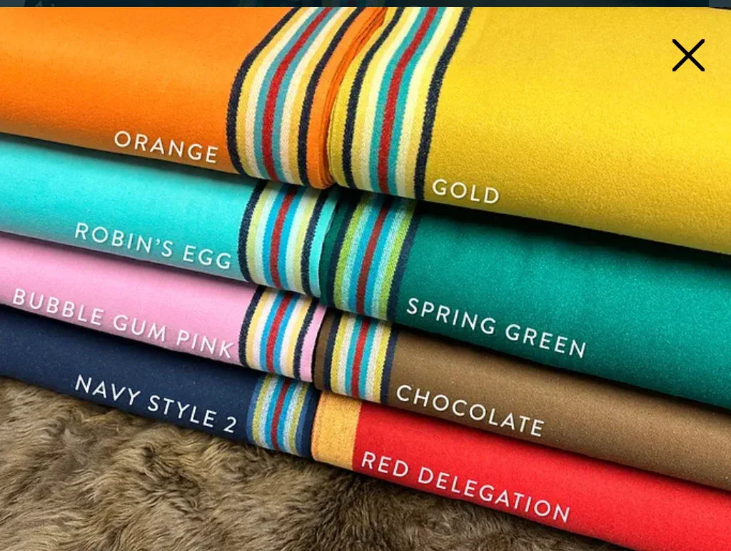 Vibrant fabric rolls in orange, gold, pink, green, navy, chocolate, red for Native art crafts