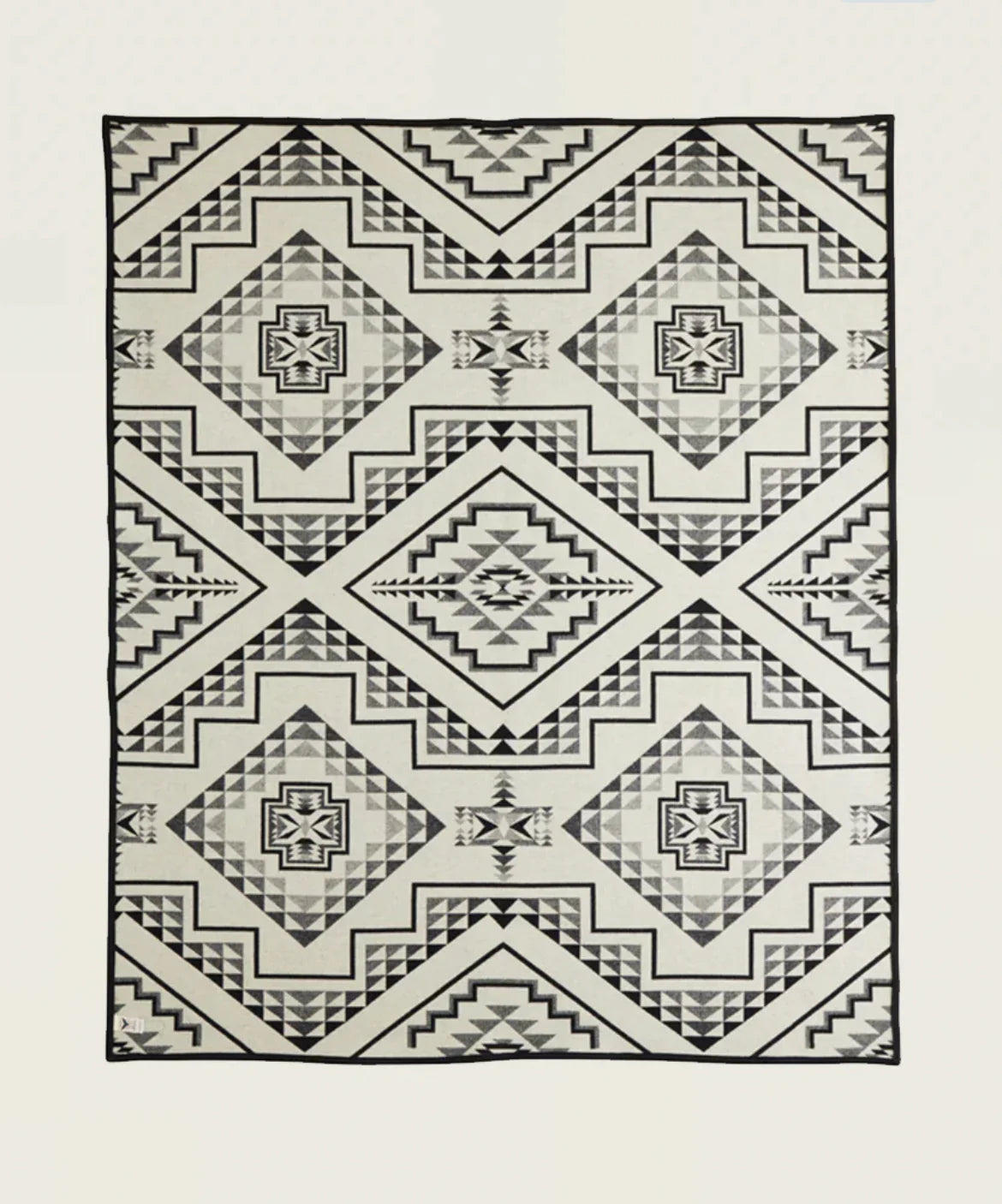Native American geometric patterned blanket with diamond and zigzag designs in black, gray, and white.