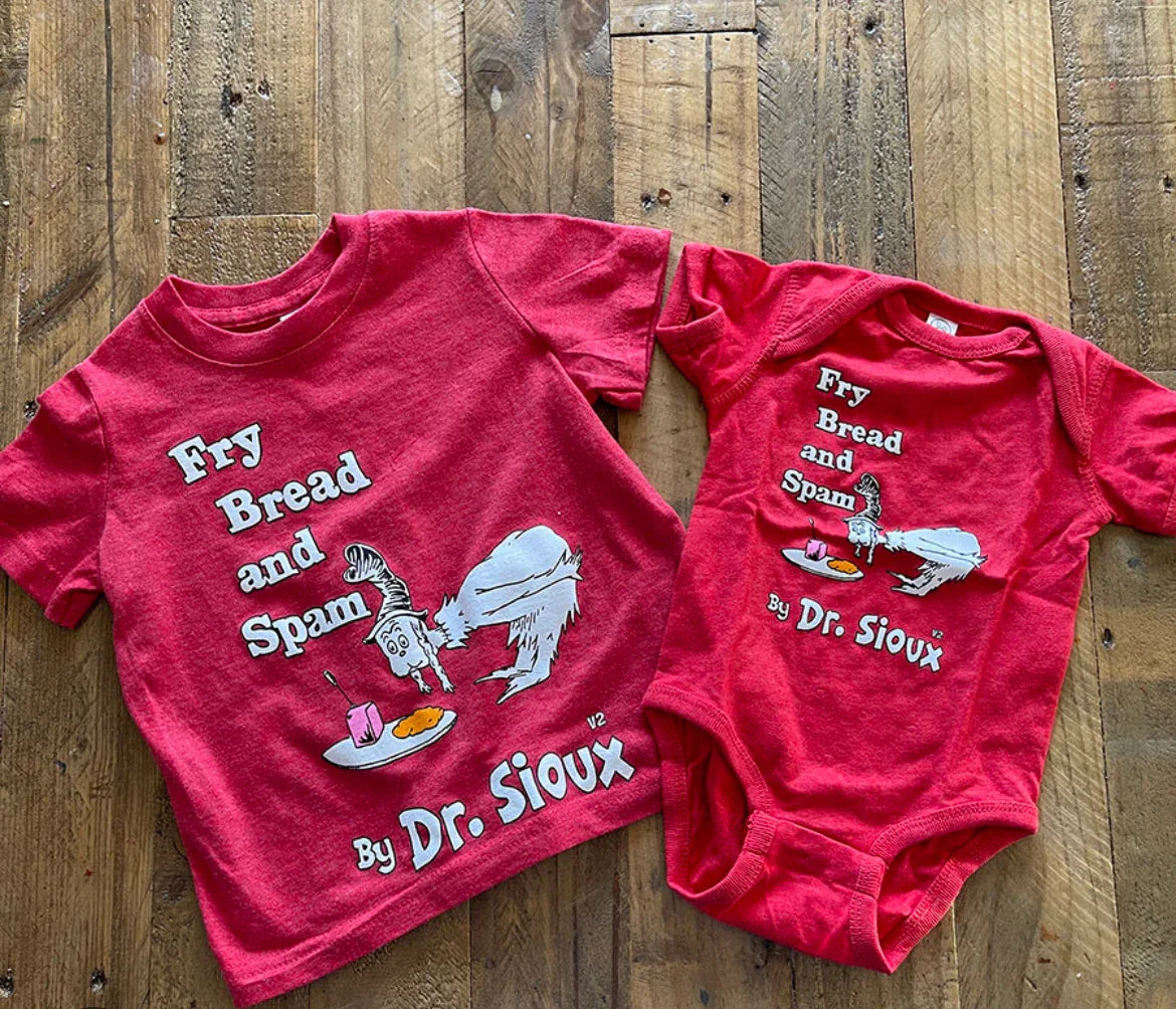 Red Dr. Seuss 'Fry Bread and Spam' toddler tee and baby onesie on wood floor