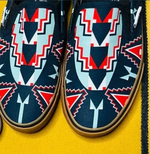 Native American patterned slip-on shoes with geometric red, white, and navy designs on yellow background