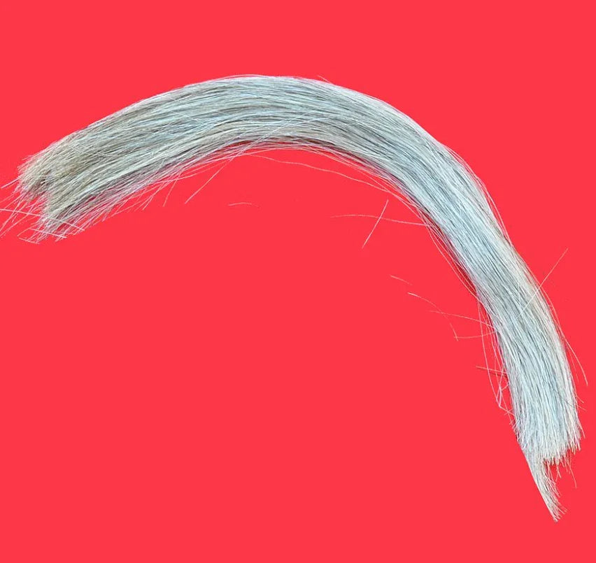 Natural gray horsehair for Native American crafts and traditional clothing, set against red background