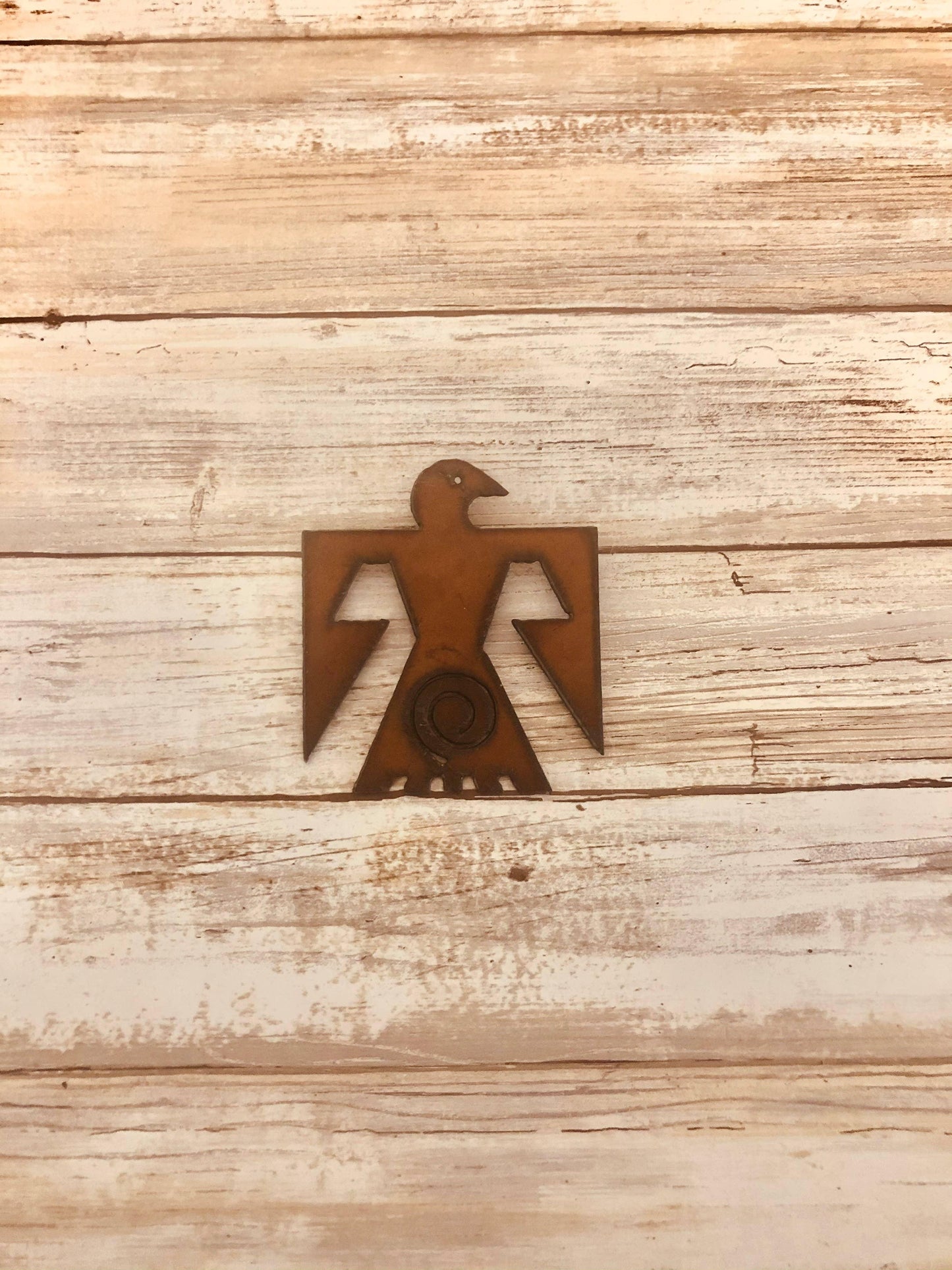 Native American metal bird art with geometric wings on rustic wood, ideal for traditional craft decor