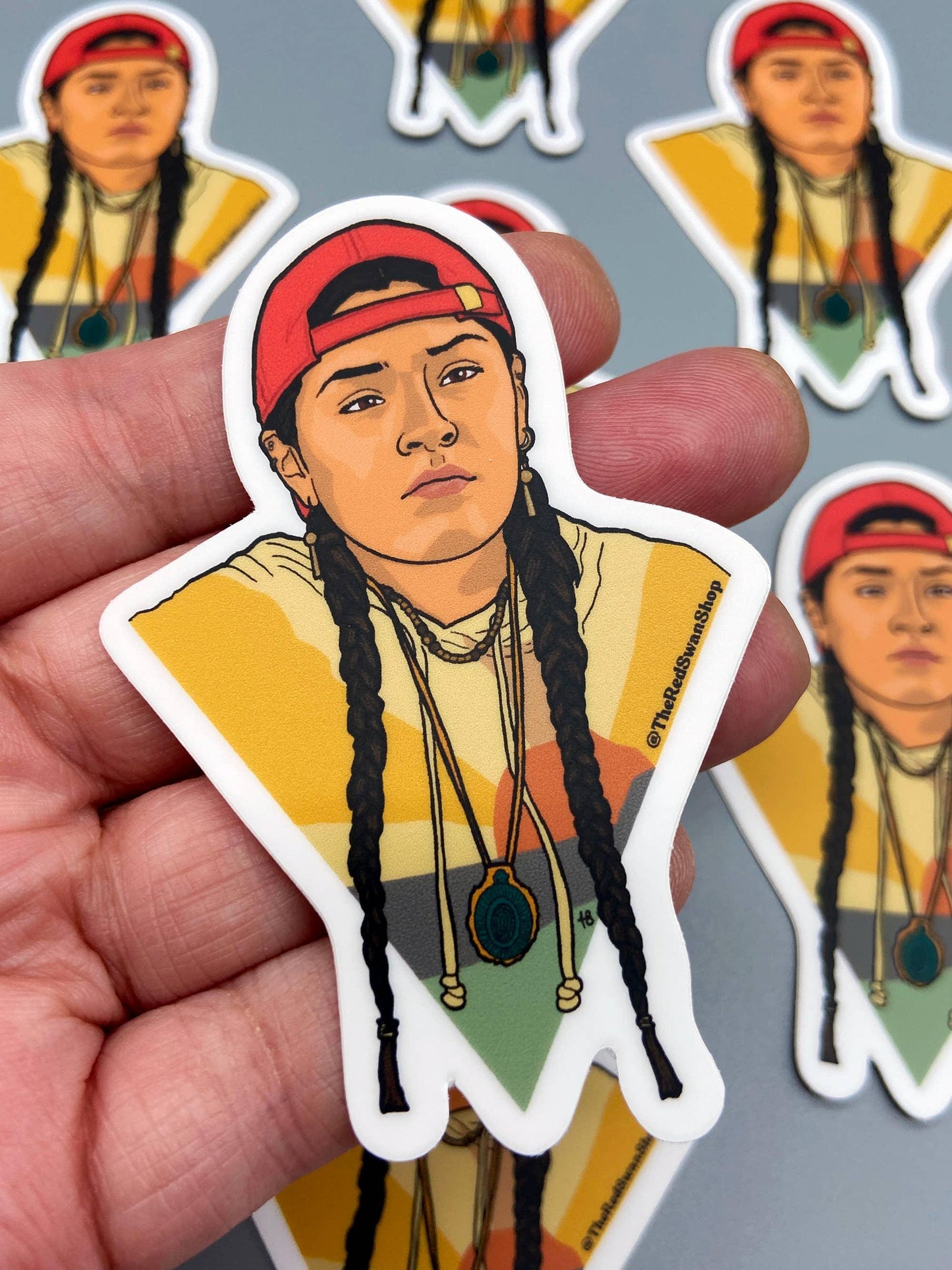 Native American art sticker with braided hair, red cap, and beaded necklace, perfect for crafts and cultural decor.