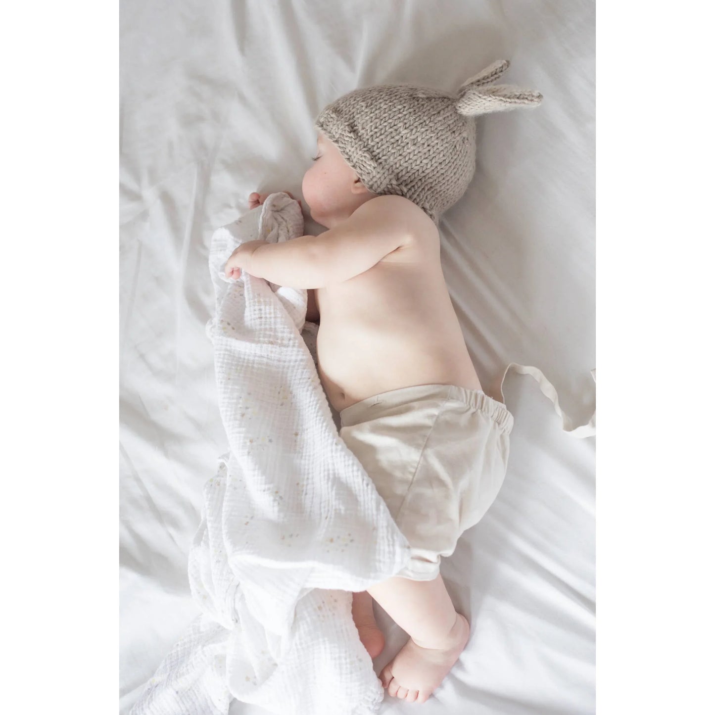 Baby sleeping in knitted bunny hat and soft blanket, cozy newborn outfit