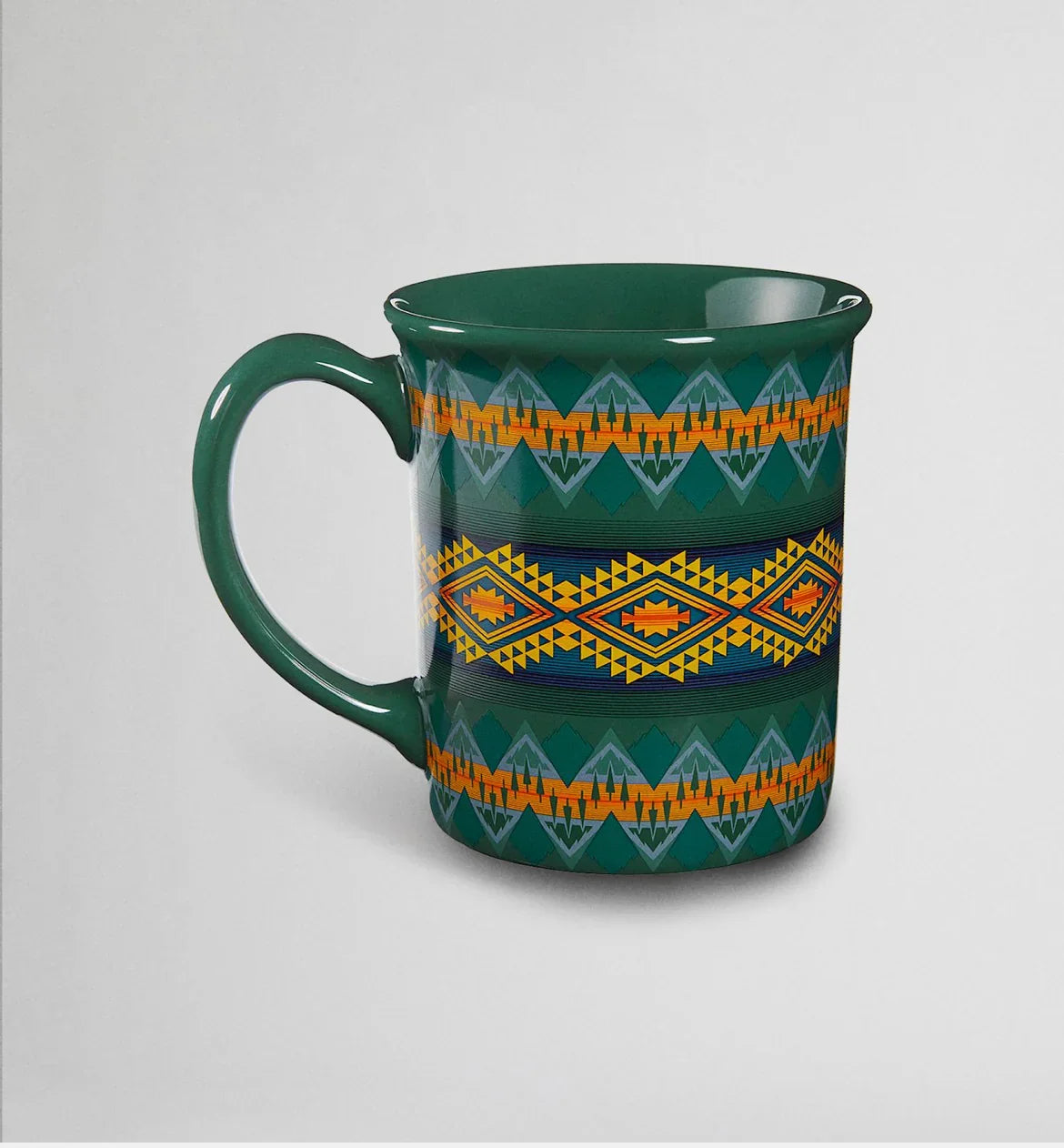 Green ceramic mug with vibrant Native American geometric patterns in orange, yellow, and blue.