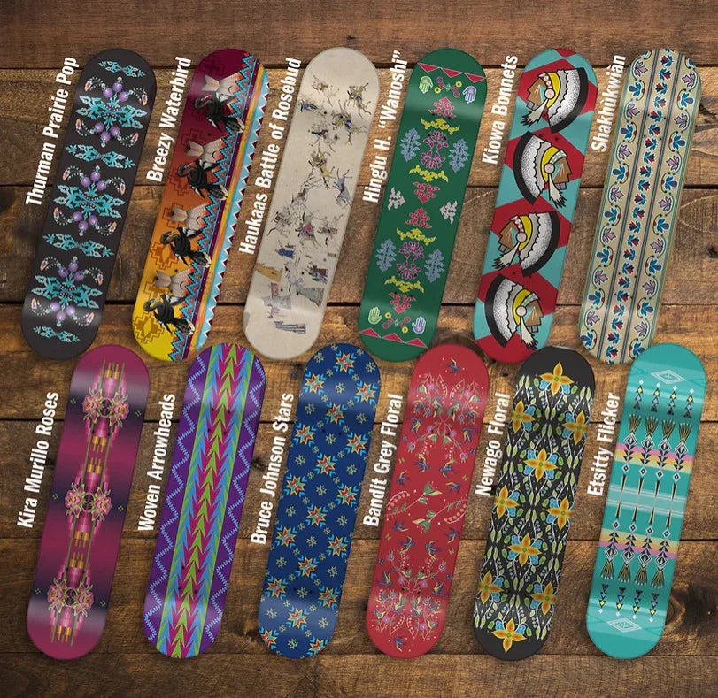 Colorful Native-inspired skateboard decks with tribal patterns and artist names on wooden display