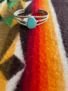 Turquoise stone silver cuff bracelet on colorful Native American blanket