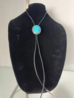 Turquoise bolo tie on black display stand, Native American jewelry with silver accent