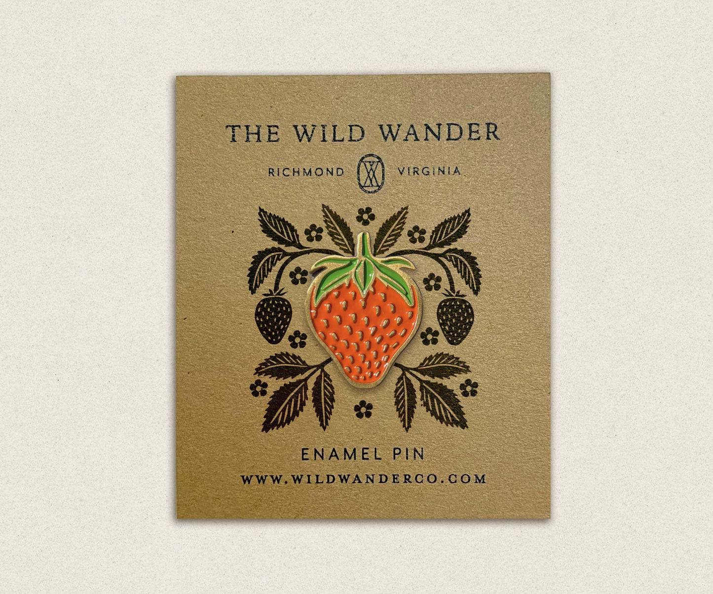 Strawberry enamel pin with leafy design on kraft card, artisan craft accessory