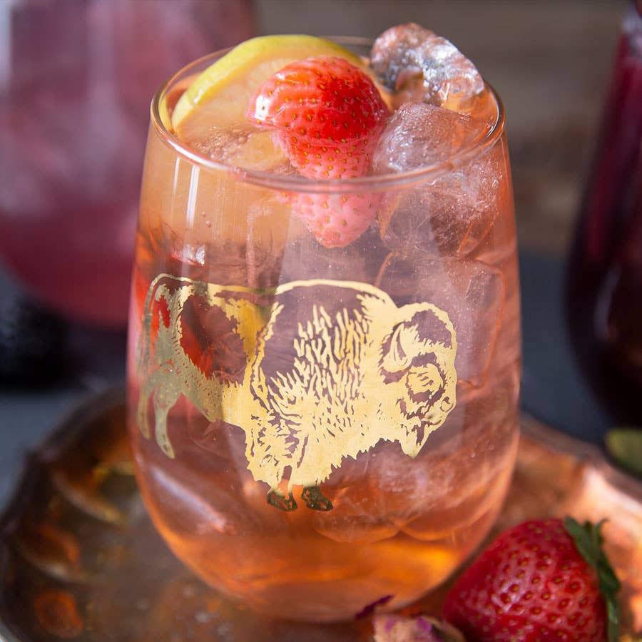 Gold buffalo etched glass with iced drink, strawberry, lemon slice — perfect for Native art lovers