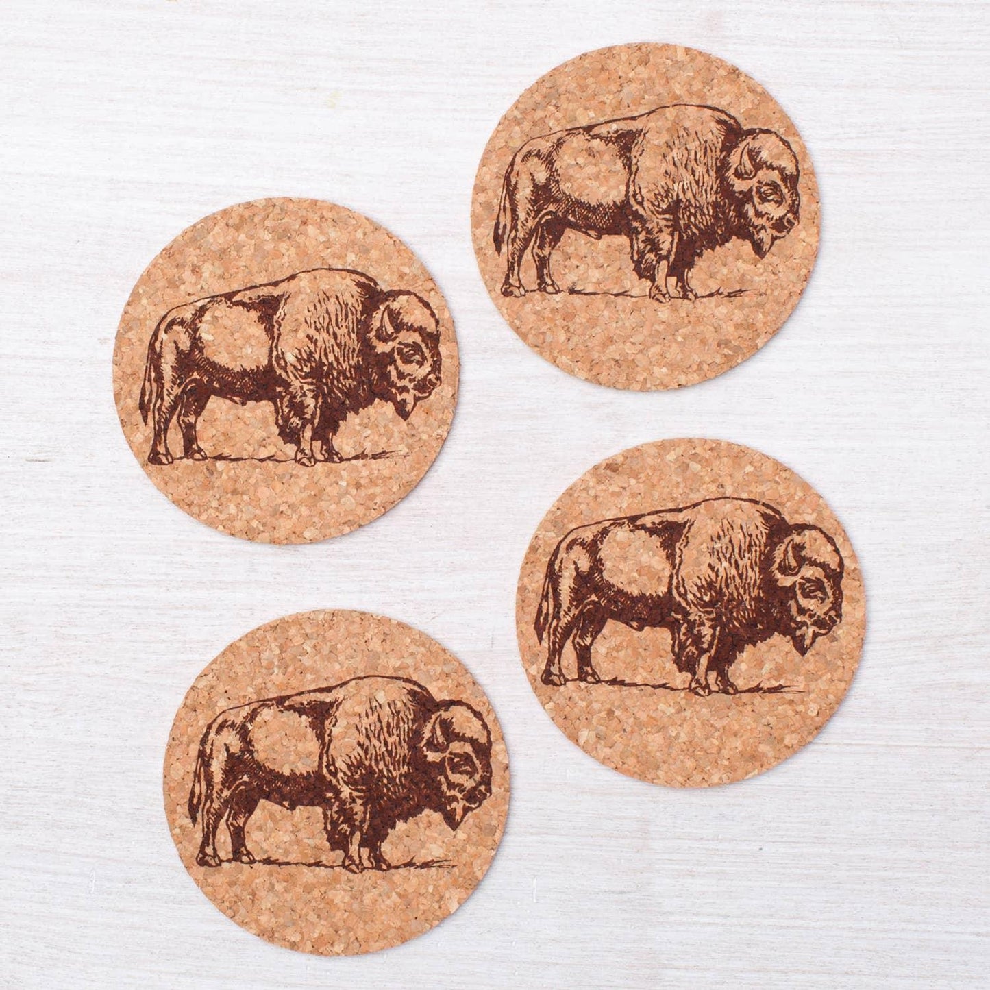 Set of four cork coasters with engraved bison designs, rustic Native American art style
