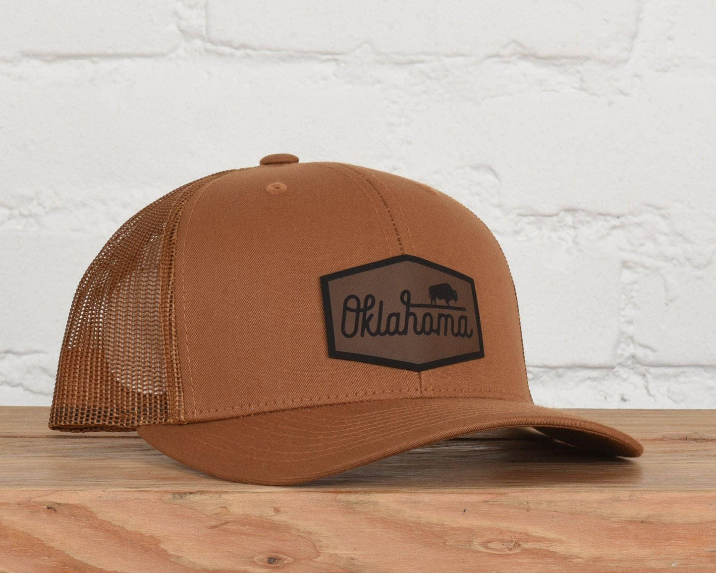 Brown trucker hat with Oklahoma bison logo, perfect for Native art and craft enthusiasts.